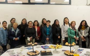 Grupo de mujeres en ciencias posa detras de la mesa donde compartieron un desayuno para proyectar el rol femenino en las ciencias.