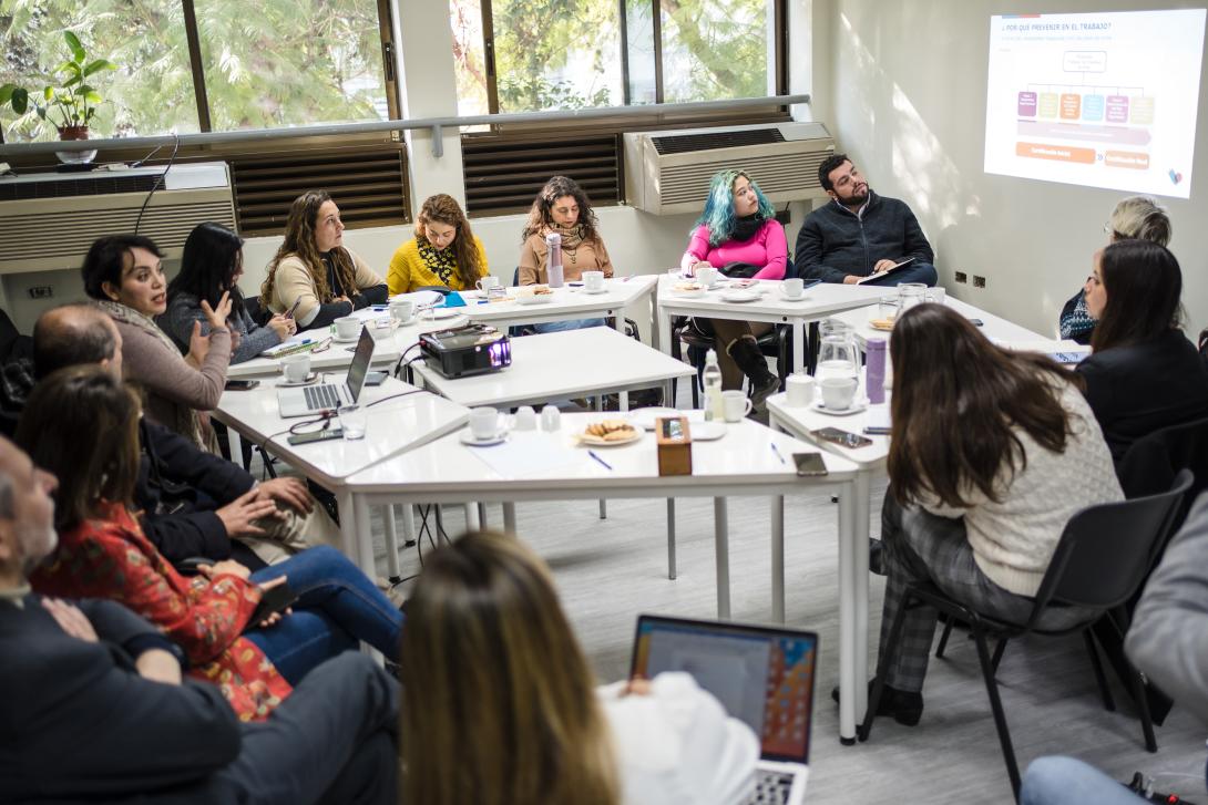 Participantes en la charla conversan con las autoridades.